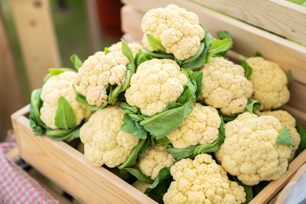 Beautiful,Cauliflower,With,Green,Leaves,In,A,Wooden,Crate