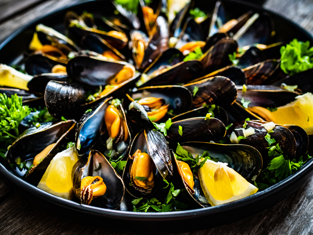 Cooked,Mussels,With,Lemon,And,Parsley,On,Wooden,Table