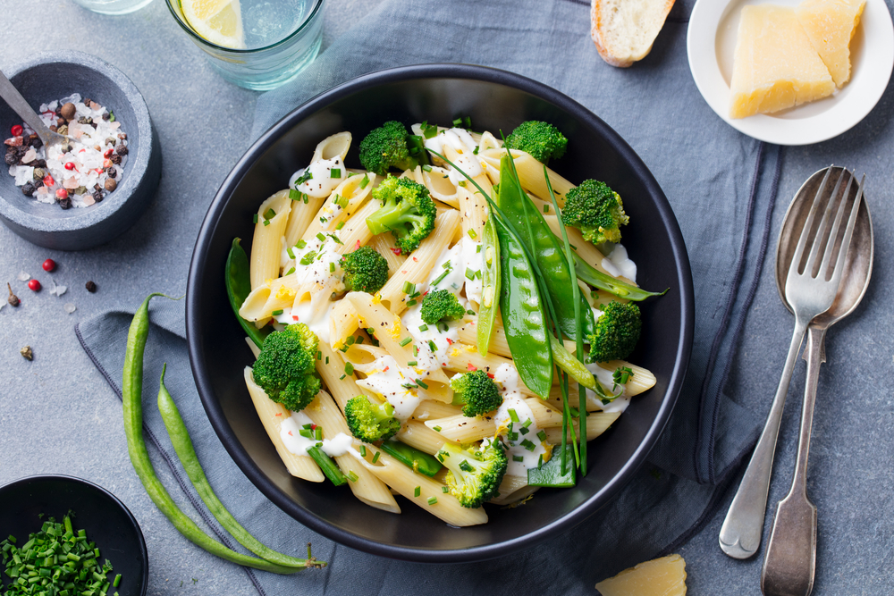 Pasta,With,Green,Vegetables,And,Creamy,Sauce,In,Black,Bowl