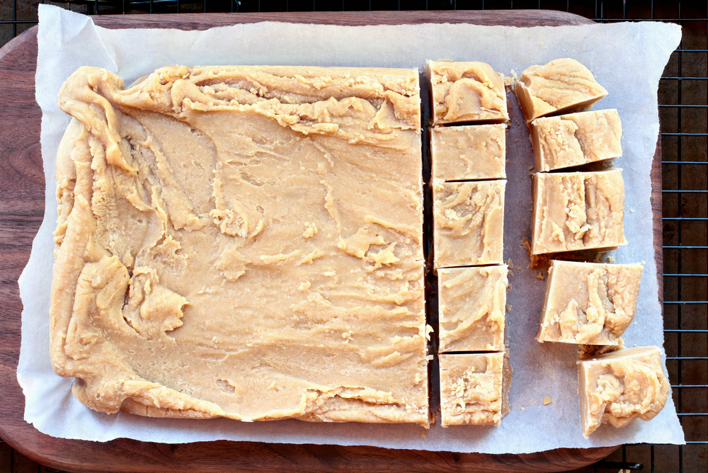 Delicious Homemade Peanut Butter Fudge over Cutting Board