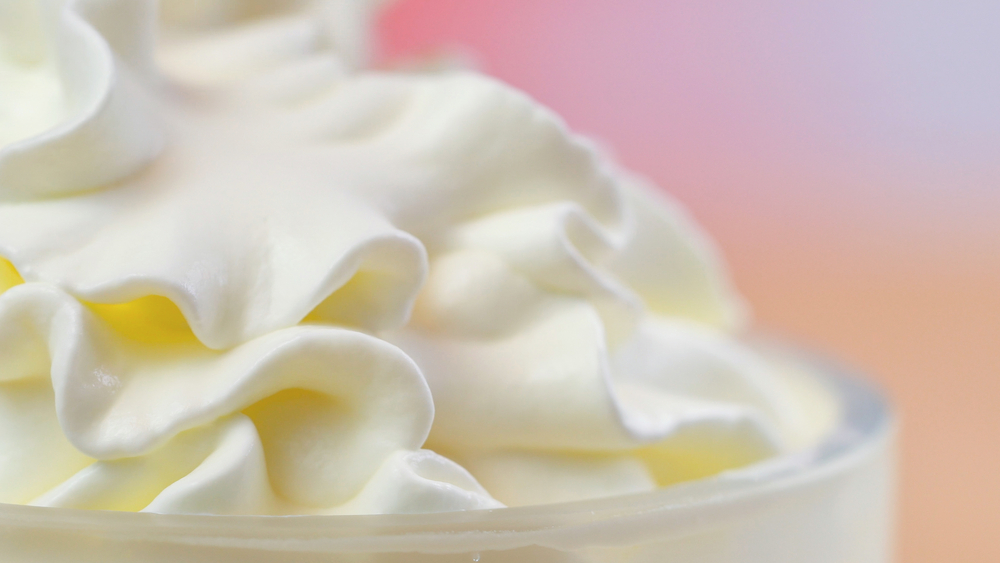 Macro closeup of swirls of whipped cream for cake decorating.
