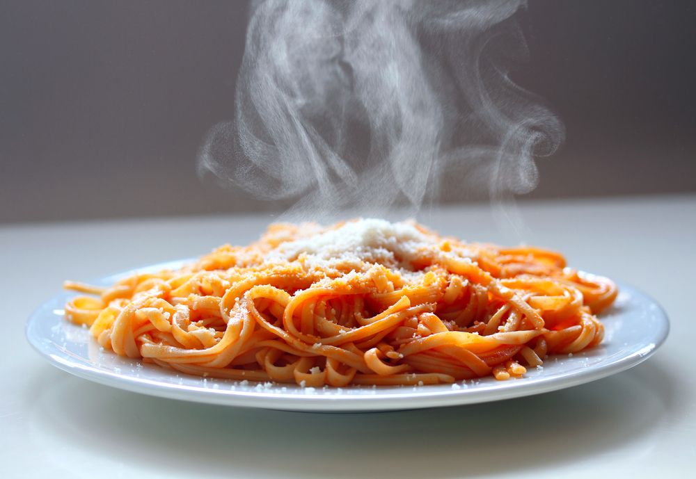 Italian spaghetti steaming with parmesan cheese.